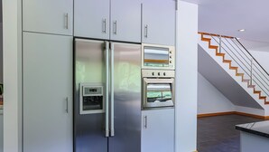A modern kitchen with a built-in refrigerator, oven, and microwave.