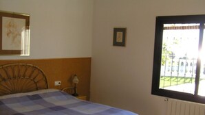 A bedroom with a bed, a window with a view, a lamp, and a framed picture on the wall. - BENALMADENA Villa Apartment,close to beach, nice private pool Internet/Wifi (Benalmádena)