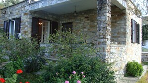 A stone house with a porch, windows with shutters, and a garden with flowers. - Perfect for a for a quiet relaxing vacation, very close to 2 of the best beaches (Tinos)
