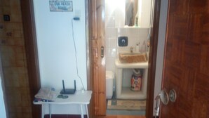A hallway with a tiled floor, a white bench, a sign reading "OUR BEACH HOUSE", and a bathroom visible through an open door. - Perfect for a for a quiet relaxing vacation, very close to 2 of the best beaches (Tinos)