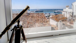 A telescope on a tripod, a tiled roof, and a marina with boats. - Puerto Banus, Marbella Luxury in centre of port amazing views near golf<br> (Marbella)