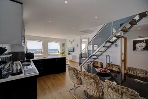 A modern kitchen with a large island, a dining area with patterned chairs, and a staircase leading to an upper level. - Puerto Banus, Marbella Luxury in centre of port amazing views near golf<br> (Marbella)