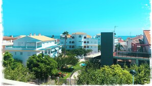 Un pueblo costero con edificios, cielo azul despejado y vista al mar.