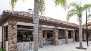 A restaurant with a patio area, stone columns, and palm trees. - South View Luxury 5★ Villa: Pool, Spa, Game Room, Near Disney & Universal (Davenport)