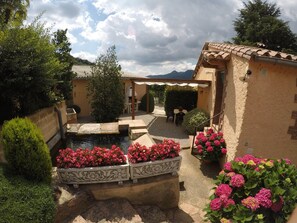 A courtyard with a small pond, potted flowers, and a seating area under a pergola. - Self catering Mas Romeu for 4 people (Arbúcies)