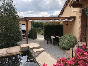A patio area with a pergola, outdoor seating, a small water feature, and a view of mountains. - Self catering Mas Romeu for 4 people (Arbúcies)