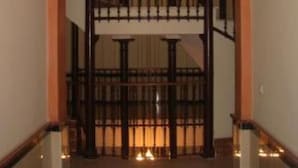 A staircase with a wooden railing and a light fixture above. - Beautiful apartment in  historical recently reformed building. (Sevilla)