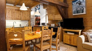 Ein Holzinterieur mit Essbereich, Küche und Wohnraum.