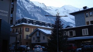 Ein Hotel mit Blick auf die Berge, mit einem mit Schnee bedeckten Dach und einem gut sichtbaren Schild.