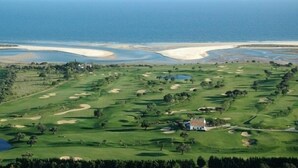 Ein Golfplatz mit Bunker, Wasserhindernissen und einem Clubhaus.