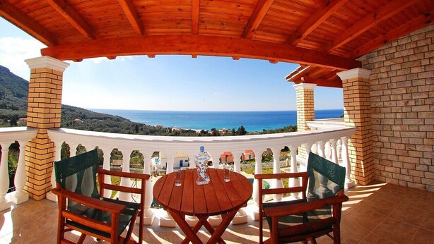 A wooden pergola with a table and chairs overlooking a scenic view of the sea and hills. - Private Villa with superb seaview, swimming pool, garden, parking, pet friendly (Corfu)