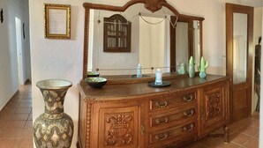 A wooden dresser with a mirror, a vase, and decorative items on top. - Calm, serene, secluded, stunning gardens, pool close to beach and all amenities  (Binibequer)
