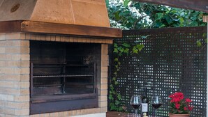 An outdoor brick oven with a wooden countertop and a potted plant. - Fabulous family Villa with pool, 500 m from the beach, for 6 people (Alcúdia)