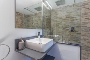 Een bad/douchecombinatie, een haardroger, een bidet, handdoeken