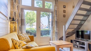 A living room with a sofa, a coffee table, a TV, and a staircase.