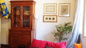 A bedroom with a red bed, a wooden cabinet, framed pictures on the wall, and a flag. - Period residence located in the heart of Siena (Siena)