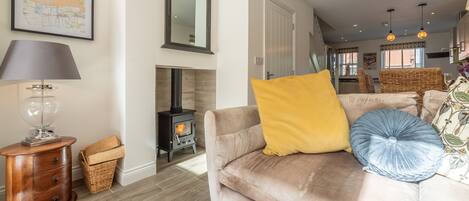 A cozy living room with a sofa, a lamp, a fireplace, and a map on the wall.