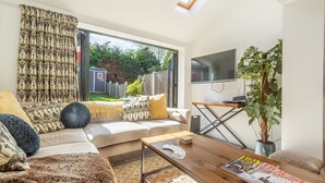 A modern living room with a sofa, coffee table, and a TV. - Driftwood Cottage, Brancaster, Norfolk (King's Lynn)