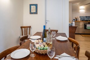 Ett matbord dukat med tallrikar, vinglas, en korg med bröd och en vinflaska.