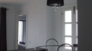 Eine moderne Küche mit einer zentralen Kochinsel, Pendelleuchten und Blick auf den angrenzenden Essbereich.