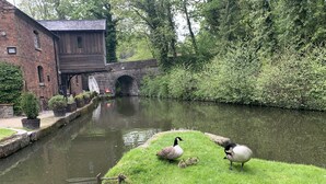 A canal with ducks and geese, a brick building, and a stone bridge. - 5* STUNNING LUXURIOUS BEAMED COTTAGE - SECLUDED PEACEFUL PEAK DISTRICT LOCATION (Leek)