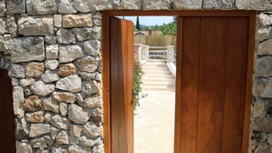 Un muro de piedra con una puerta de madera que da a una escalera.