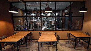 A conference room with a large table and chairs, a view of industrial equipment through large windows, and pendant lighting. - Villa with pool in Tuscany, close to San Gimignano and Volterra  (Villamagna)