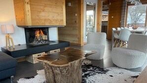 Un soggiorno moderno con camino, una stuoia in pelle di vacca e arredi contemporanei.