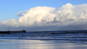 Une jetée qui s’avance dans l’océan, avec des vagues qui se brisent sur le rivage.