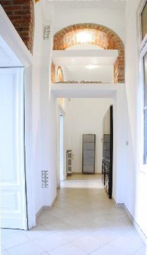 Corridors lead to rooms with distinctive arched features above doors.