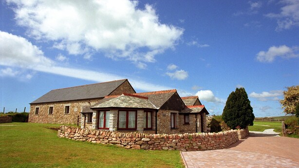 A stone building with a red-tiled roof, a stone wall, and a paved pathway leading to the entrance. - 2 bedroom cottage on Bodmin Moor (Bodmin)