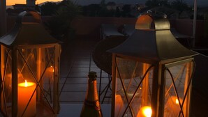 A terrace with two lanterns, a bottle, and a plate. - BEAUTIFUL PENTHOUSE DIRECT PRIVATE  BEACH 4 BEDS (Marbella)
