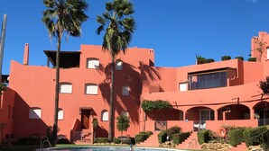 A building with a pool, palm trees, and a clear blue sky. - BEAUTIFUL PENTHOUSE DIRECT PRIVATE  BEACH 4 BEDS (Marbella)