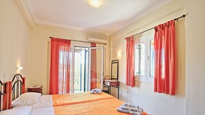 A hotel room with two beds, a desk, a chair, and a window with curtains. - Mattheos House: A tranquil two bedroom apartment, just a few steps away from Kalami popular beach (Kalami)