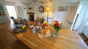 A dining table set with breakfast items, a clock, and a lamp. - Charming Seaside Home, Full of Character (Old railway carriages) Pet Friendly,  (Chichester)