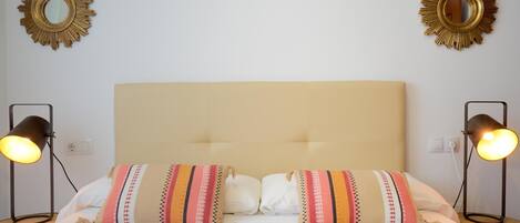 Ein Hotelzimmer mit einem großen Bett, zwei Nachttischlampen und zwei Wandspiegeln.