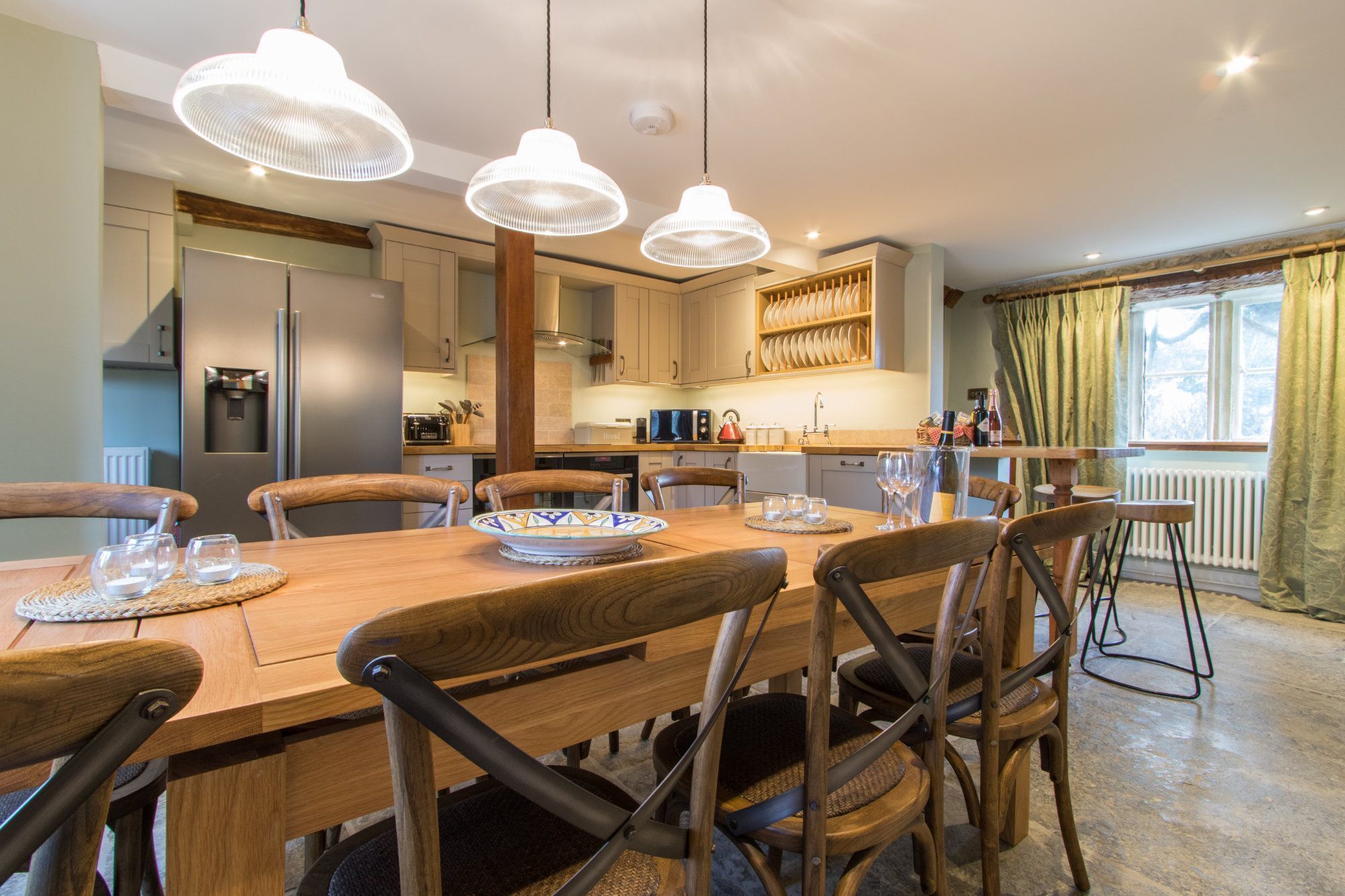 A modern kitchen with wooden cabinets, a built-in oven, and a dining area with a wooden table and chairs.