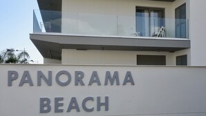 Een gebouw met een bord waarop 'PANORAMA BEACH' staat.