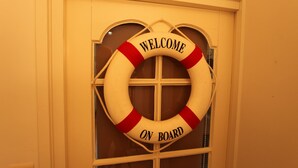 A lifebuoy with "WELCOME ON BOARD" text on a door. - Studio Havenzicht on top location in the historic town of Veere (Veere)