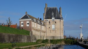 Een historisch kasteel met een opvallende toren, een geplaveid pad en een bank.