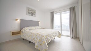 Une chambre à coucher avec un lit, une table de chevet et une fenêtre avec des rideaux.