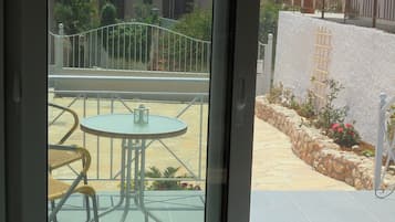 Enjoy a peaceful moment on this balcony overlooking a serene garden with a beautiful view.