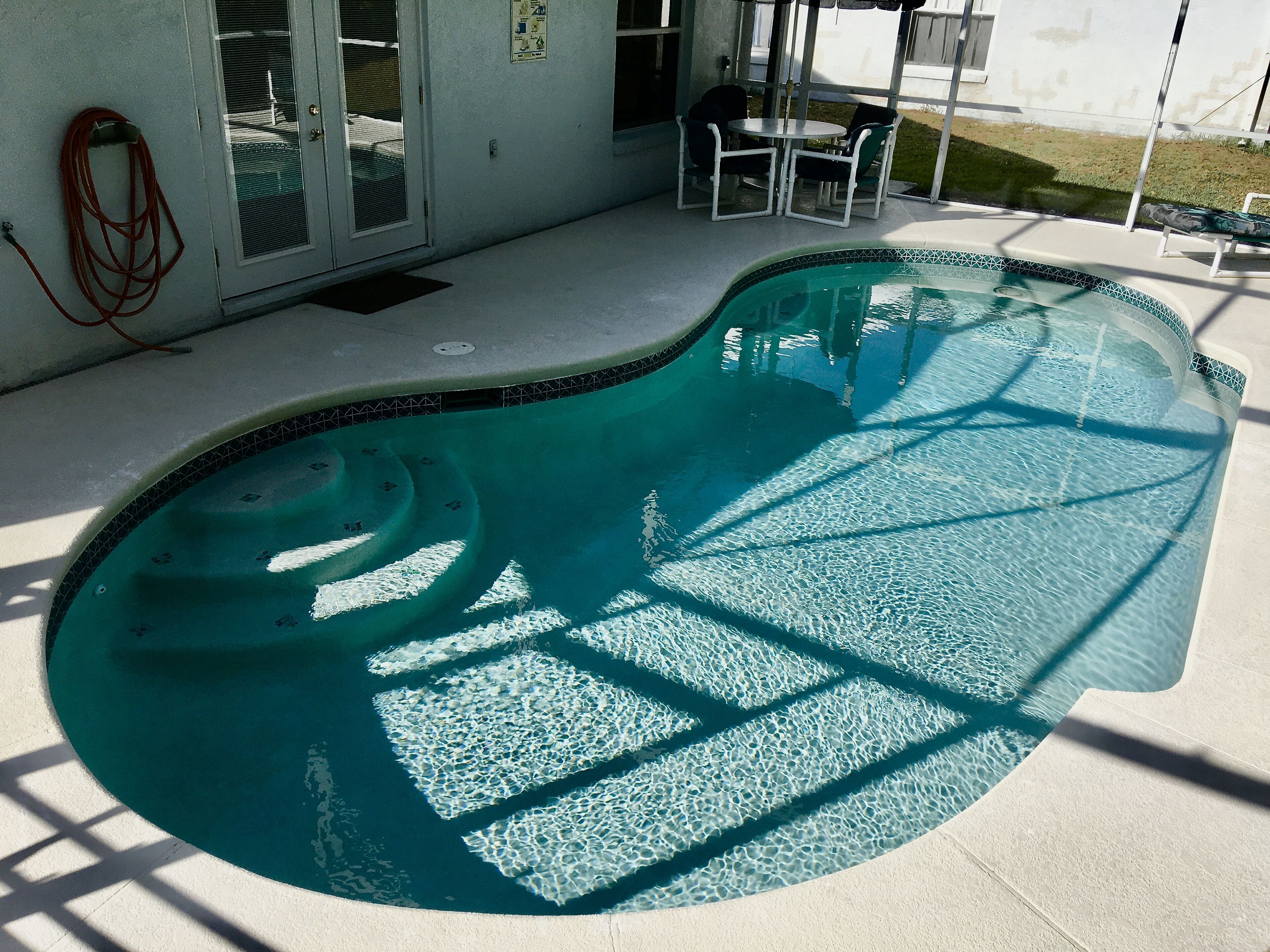 A swimming pool with a tiled edge and a clear blue interior.