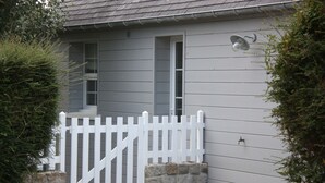 A building with a white picket fence, a stone base, and a gravel driveway.
