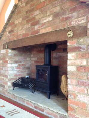 Cozy warmth is found in this traditional fireplace with a wood-burning stove.