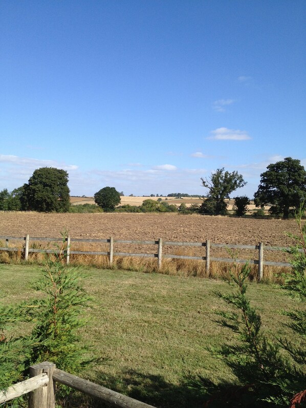 A rural landscape with a wooden fence, fields, and trees under a clear sky. - Pool Meadow cottage - Knollands Farm (Knollands Farm)