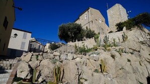 A stone building with a tower, surrounded by cacti and rocks. - Antibes Old Town, Sunny, South facing apartment 2 Balconies, fully air condition (Antibes)