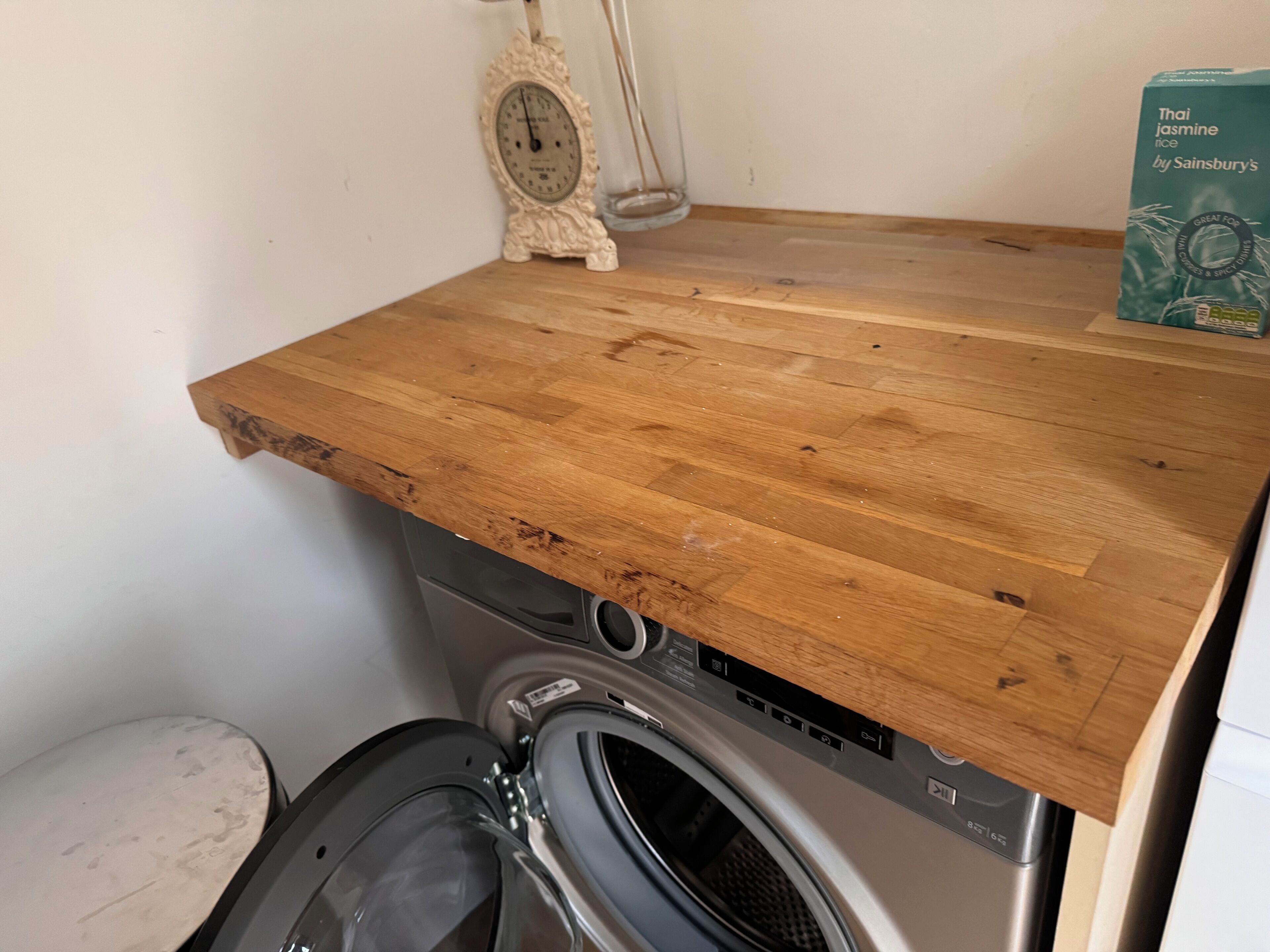 Un plan de travail en bois avec un lave-linge placé en dessous.