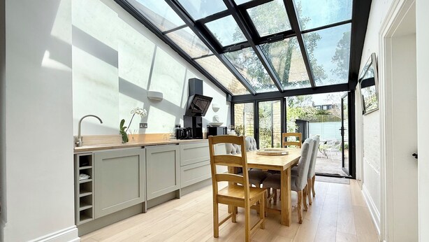Una cocina moderna con un amplio ventanal, muebles de madera y una estufa integrada.