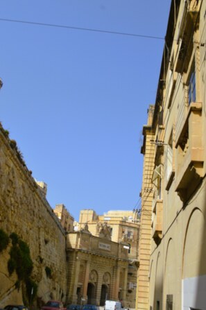 A street view with a stone building, a clear blue sky, and parked cars. - Grand Harbour, Valletta, Malta - sleeps six (Ta'Liesse)